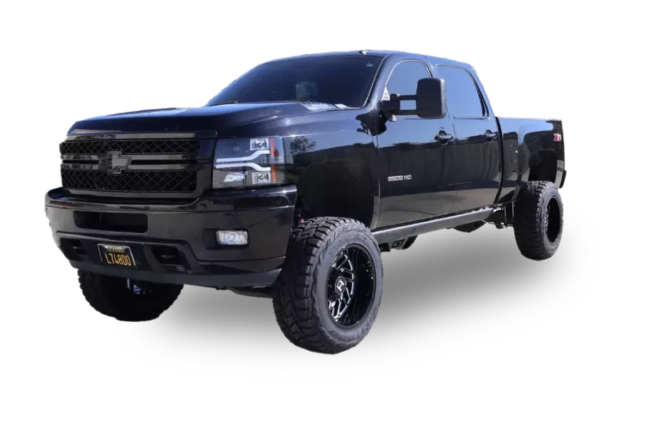 A black, lifted Chevrolet Silverado 2500 HD truck with large off-road tires is shown. The vehicle features an extended cab and tinted windows, with a license plate that reads "LTZ1000". The truck is photographed against a white background.