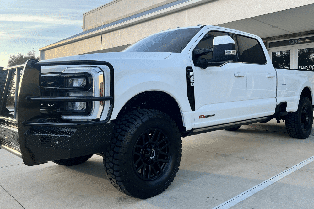 winter diesel service, auto repair in St Cloud, FL at FloState Auto Diesel Repair. Image of a white Ford Super Duty truck equipped with rugged tires and accessories.