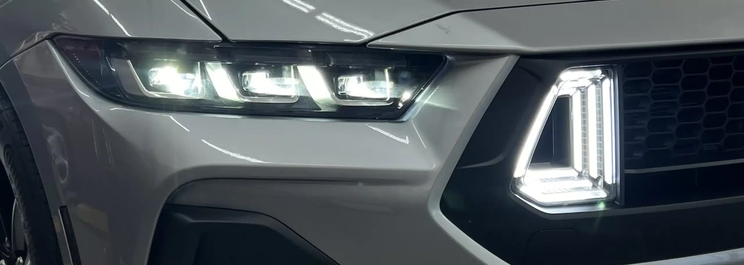 Close-up view of a vehicle's modern LED headlights and grille design.