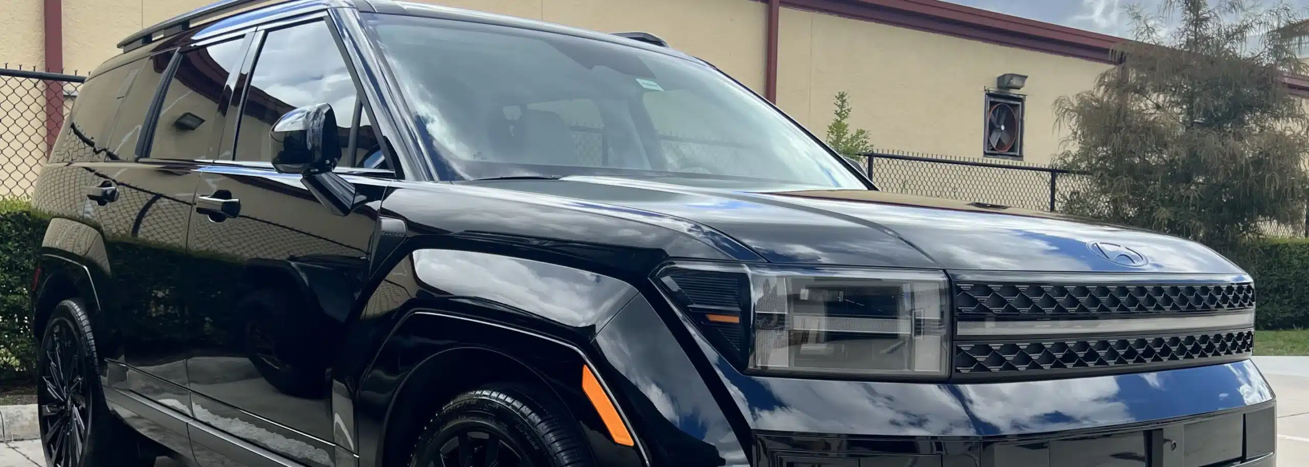 An image of a shiny black SUV parked outside