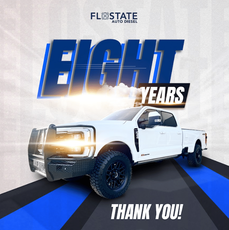 A white pickup truck with illuminated headlights and bold text reading "EIGHT YEARS" and "THANK YOU!" with the FloState Auto Diesel logo above.