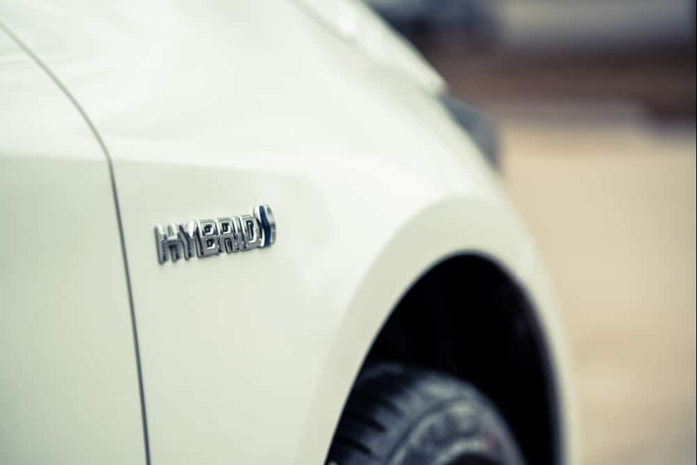 Hybrid Repair in St. Cloud FL At FloState Auto Diesel Repair. Close-up view of a car’s hybrid badge on the exterior panel.