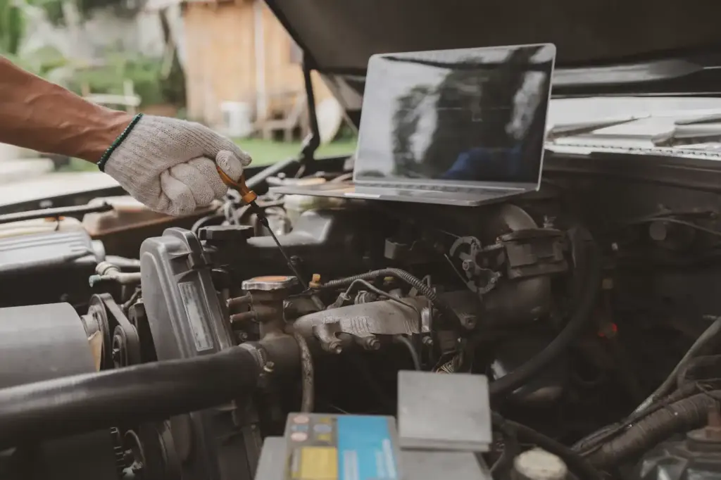 Technician performing vehicle engine diagnostics using professional diagnostic equipment