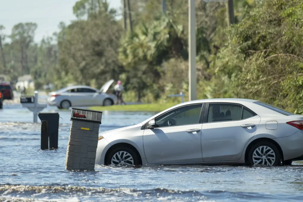 Flooded american street with stuck vehicle surroun