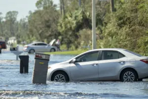 Flooded american street with stuck vehicle surroun